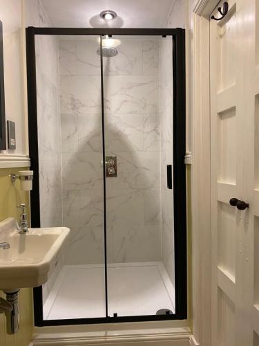 a shower with a glass door next to a sink at 7 Goathill Crescent in Stornoway