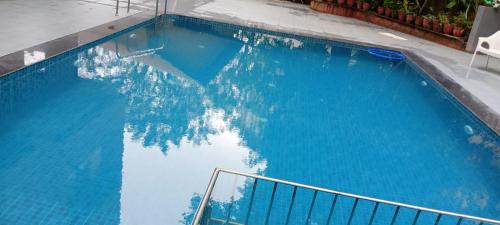 a large blue swimming pool with a reflection in the water at Star Regency Resort & Spa in Lonavala