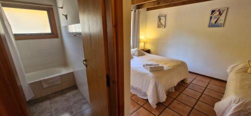 1 Schlafzimmer mit einem Bett und einer Badewanne sowie einem Bett von sidx sidx sidx sidx sidx in der Unterkunft Complejo Base 41 in San Carlos de Bariloche