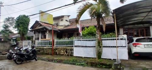 a motorcycle parked in front of a house with a fence at OYO 94801 Pad Guest House in Bandung