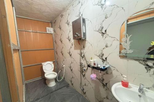 a bathroom with a toilet and a sink at OYO 94841 Alodia Homestay Family in Kejajar