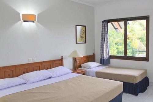 a bedroom with two beds and a window at OYO 94841 Alodia Homestay Family in Kejajar