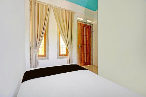 Un pat sau paturi într-o cameră la OYO 94834 Homestay Arjuna Near Taman Safari 2 Prigen