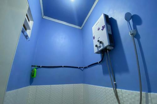 a blue bathroom with a shower in a room at OYO 94839 He-ha Homestay Syariah in Kejajar