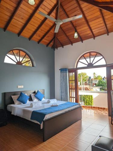 a bedroom with a large bed in a room with windows at Hotel Transylvania - Negombo in Negombo