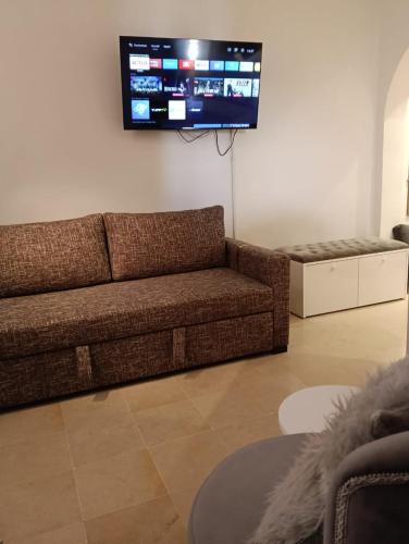a living room with a couch and a flat screen tv at Appartement Yasmine Hammamet in Yasmine