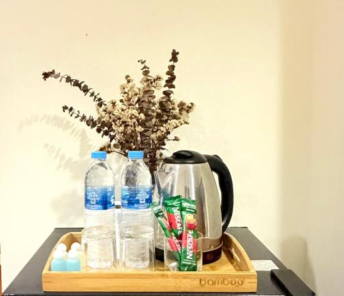 a tray with a tea kettle and bottles of water at KT Hotel Airport in Nai Yang Beach