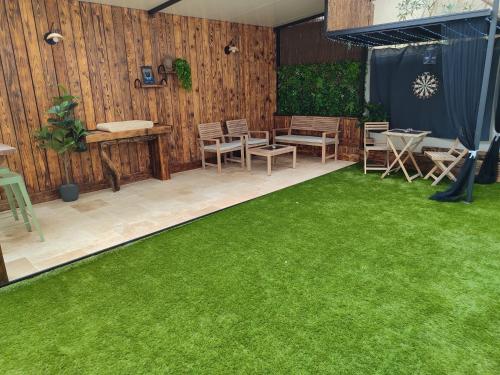 a patio with green grass and a table and chairs at Hammam et Balneo Appartement de charme You & Me in Roquevaire