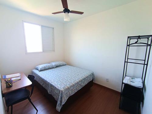 a bedroom with a bed and a ceiling fan at Flat Terras de Portinari in Barretos