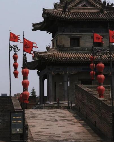 a building with chinese flags in front of it at Xi'an Bell and Drum Tower Yongning Gate Lanfeng Hotel in Xi'an