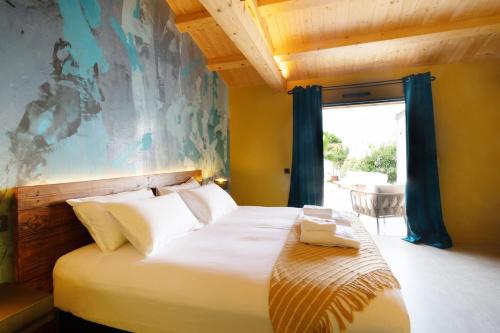a bedroom with a large bed with a large window at La Maison d'Yvonne in Grand-Village-Plage