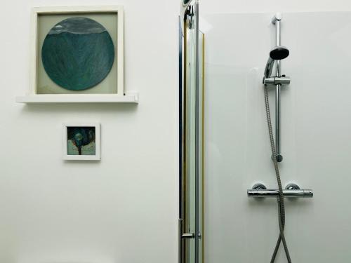 a shower door in a bathroom with a picture at Dungora House in Crieff