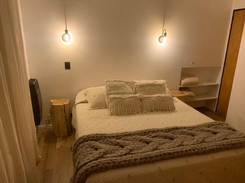 - une chambre dotée d'un lit avec une couverture et des lumières dans l'établissement Departamento Centro Bariloche, à San Carlos de Bariloche