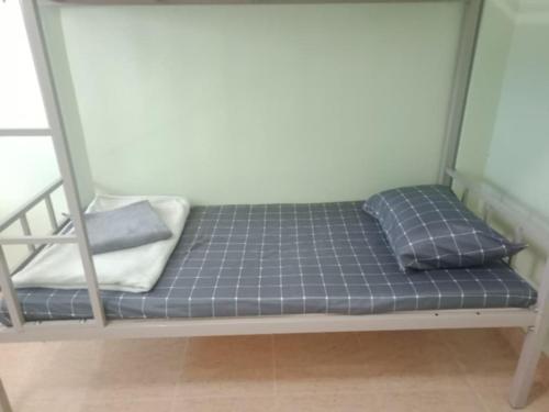 a bed in a room with two pillows on it at มังกรเลโฮสเทล Mangkonlay Hostel in Ban Khlong Pak