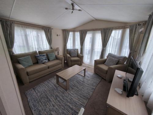a living room with two couches and a table at Sea Shore Chalet - Rockley Park in Lytchett Minster