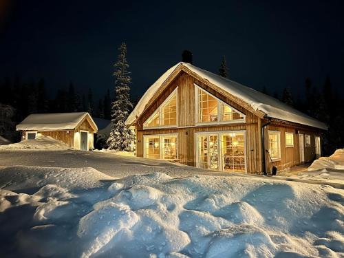 a log cabin in the snow at night at Large lovely mountain house in Vemdalsskalet in Vemdalen