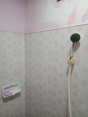 a shower head in a bathroom with pink walls at มังกรเลโฮสเทล Mangkonlay Hostel in Ban Khlong Pak