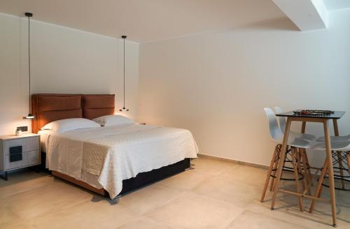 a bedroom with a bed and a table and a stool at Apademia Comfort Studio 45 sqm in Skiros