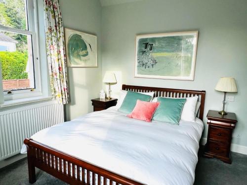 a bedroom with a bed with two lamps and a window at Ard Solas in Crieff