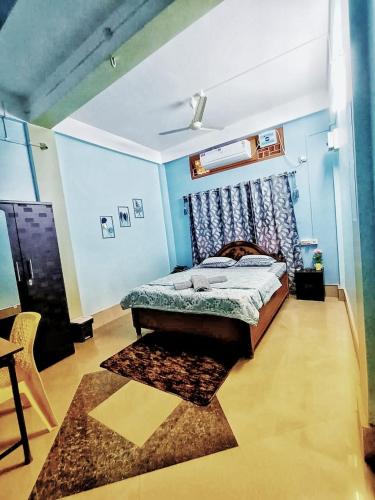 a bedroom with a bed and a blue wall at Jonaki Abax Homestay in Nowgong