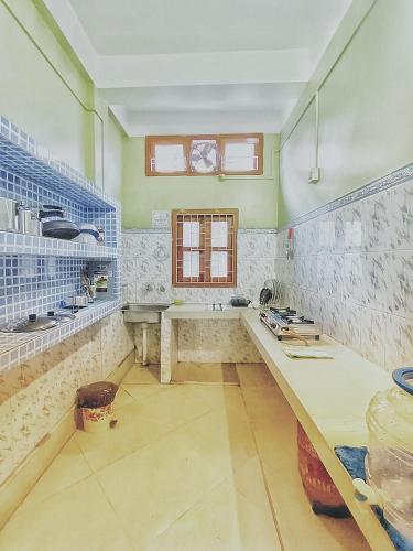 a kitchen with a counter and a window in it at Jonaki Abax Homestay in Nowgong