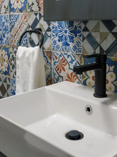a white sink with a black faucet in a bathroom at Č'a Steva Sremska kuća in Sremski Karlovci