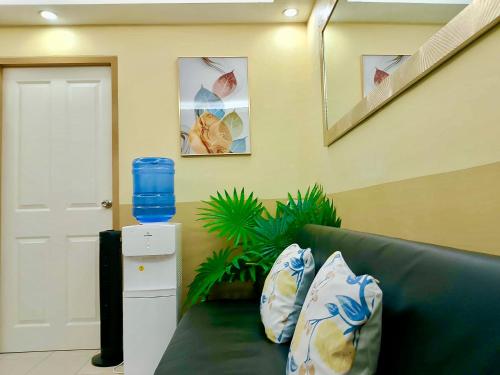 a living room with a green couch with pillows at DaLei 2-330 Sleeps 8pax at Marina Spatial Condominium in Dumaguete City in Dumaguete