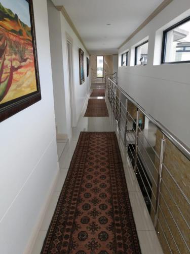 a long hallway with stairs and a rug at Ocean Vista Luxury Oubaai in Herolds Bay