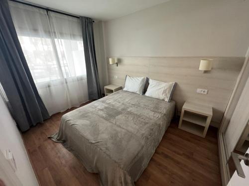 a bedroom with a bed and a large window at Apartamento Michelangelo in Salou