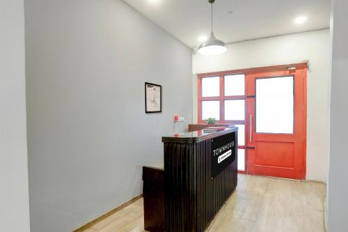 an empty room with a red door and a counter at Townhouse Nagpur Junction Formerly Hotel Woodland in Nagpur