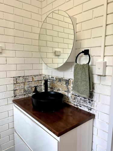 a bathroom with a black sink and a mirror at Sunrise Beachfront Getaway in Yeppoon