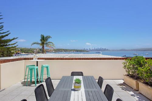 a table and chairs on a balcony with a view of the water at Watsons Bay Boutique Hotel in Sydney