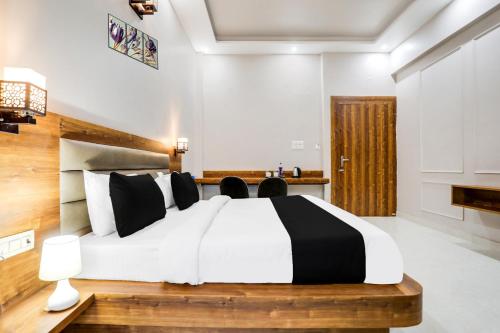 a bedroom with a large bed with black and white pillows at Super Townhouse Kathgharia Chowk in Haldwāni