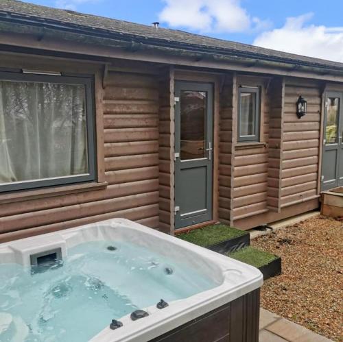 a large hot tub in front of a house at Chestnut Meadow Country Park in Sidley