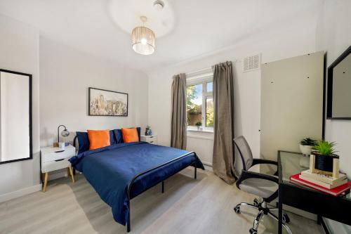 a bedroom with a blue bed and a desk at Cuckoo Avenue Hububb Stay in Greenford