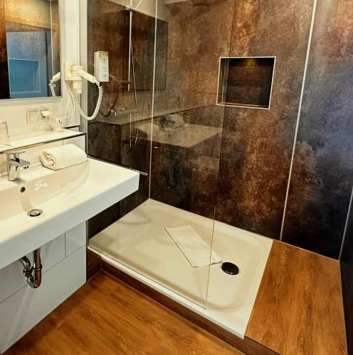 a bathroom with a shower and a sink at PANORAMA HOTEL in Neustadt an der Weinstraße in Neustadt an der Weinstraße