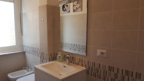 a bathroom with a sink and a mirror and a toilet at Studio apartment in the center in Lido di Ostia