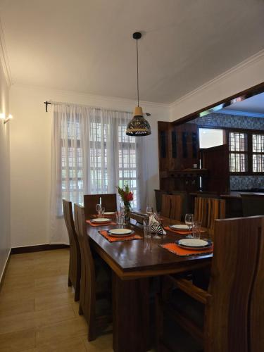 a dining room with a large wooden table and chairs at Sprunger Retreat - tulia homes in Moshi