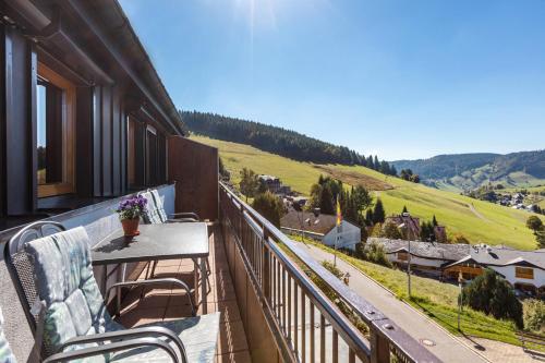 a balcony with a table and chairs and a view of a valley at Ferienwohnungen Kehrwieder in Todtnauberg
