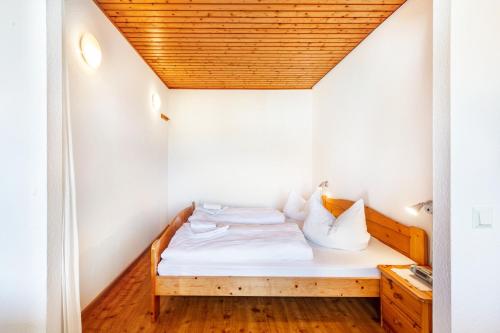 a small bed in a small room with a wooden ceiling at Ferienwohnungen Kehrwieder in Todtnauberg