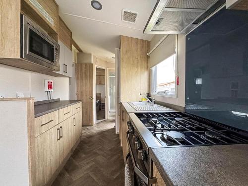 a kitchen with a stove and a counter top at Modern 6 Berth Caravan At Sand Le Mere Park, Yorkshire Ref 71002D in Tunstall