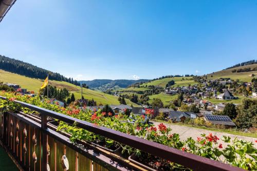 a view of a town from a balcony with flowers at Ferienwohnungen Kehrwieder in Todtnauberg