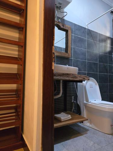 a bathroom with a toilet and a sink and a mirror at Sprunger Retreat - tulia homes in Moshi