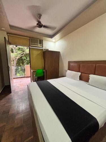 a bedroom with a large bed and a large window at Kerala Homes Near Nizamuddin in New Delhi