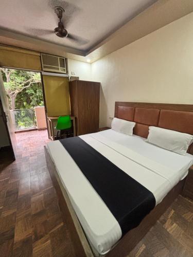 a bedroom with a bed with a black and white blanket at Kerala Homes Near Nizamuddin in New Delhi