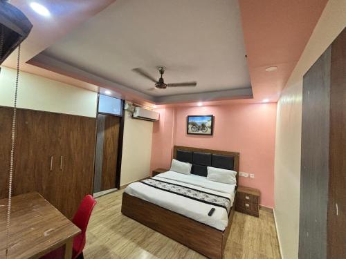 a bedroom with a bed and a desk and a table at Kerala Homes Near Nizamuddin in New Delhi