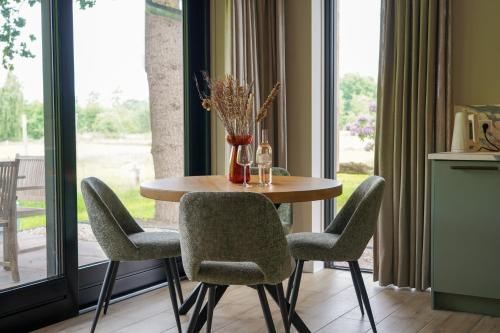 a table and chairs in a room with a window at Bos appartement voor 4 personen in De Lutte