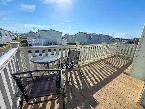 a balcony with a table and chairs on a deck at Modern Caravan With Wifi At St Osyth Beach Holiday Park In Essex Ref 28010Kv in Clacton-on-Sea