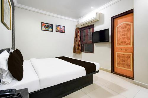 ラーイプルにあるHotel O Raipur Railway Station Formerly Hotel Okasuのベッドとテレビがあるホテルの部屋