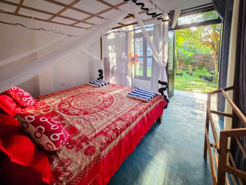 a bedroom with a bed with red and blue pillows at Sammy Villa Tangalle in Tangalle